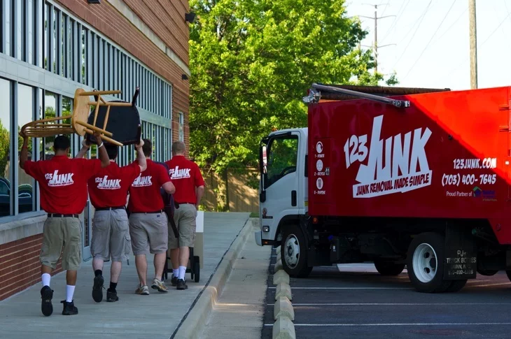 several men moving furniture outside an office