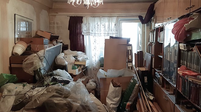 Cluttered room filled with bags, boxes, and stacked items