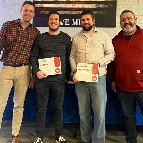 The team of 123JUNK standing together, two holding certificates during an award presentation