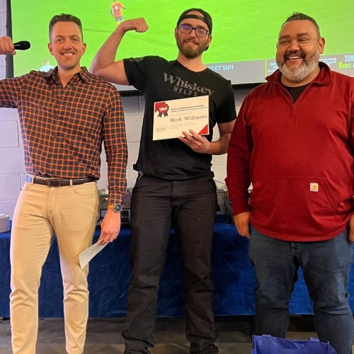 123JUNK team with one holding a certificate and flexing his arm during an award presentation