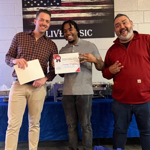 123JUNK team with the middle man holding a certificate during an award presentation