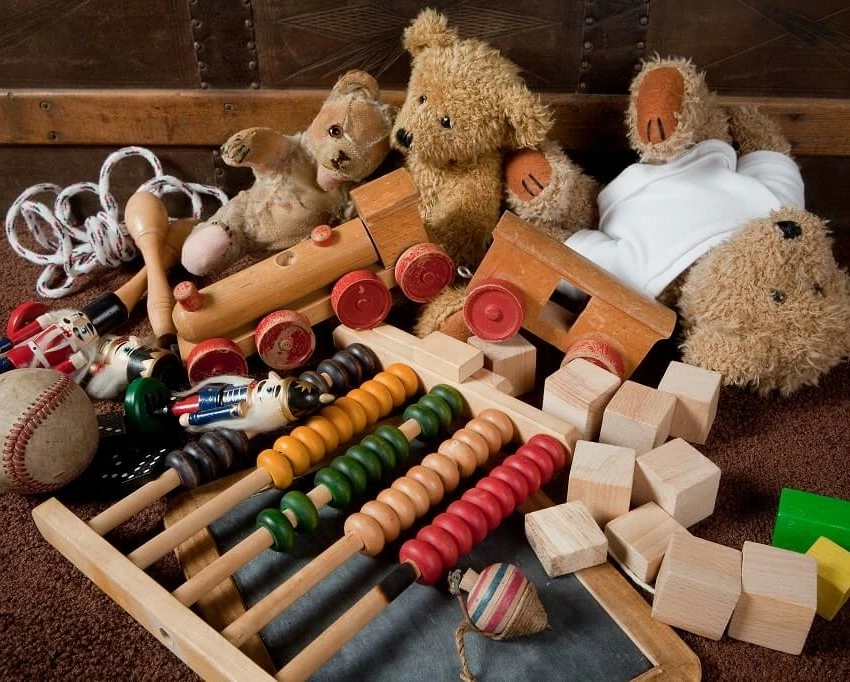 A collection of vintage toys including teddy bears, an abacus, wooden blocks, toy soldiers, and a baseball